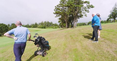 Senior golfers enjoying leisure time on picturesque golf course