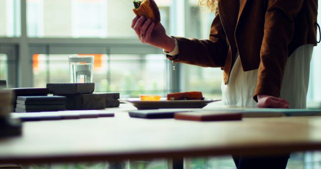 Woman Eating Sandwich and Standing by Table with Samples - Download Free Stock Images Pikwizard.com