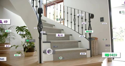 Curved carpeted staircase showing augmented reality tags in bright foyer with iron railing