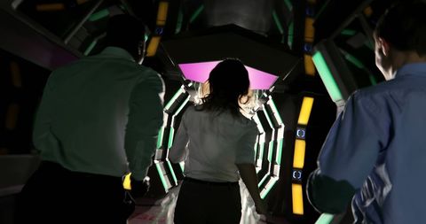 Walking Through Futuristic Interactive Exhibit with Colorful Light Patterns