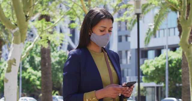 Businesswoman Wearing Mask Checking Phone Outdoors in Urban Area - Download Free Stock Images Pikwizard.com