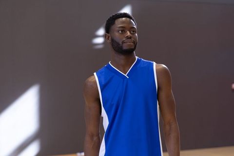 African american basketball player wearing blue jersey standing on court with focus