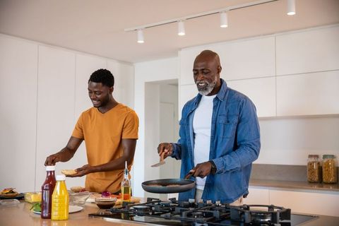 Father and Son Cooking Breakfast Together in Modern Kitchen