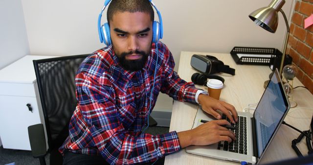 Focused Man Working on Laptop with Headphones in Office - Download Free Stock Images Pikwizard.com