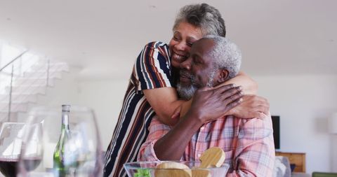 Senior Couple Enjoying Wine and Dinner with a Warm Embrace