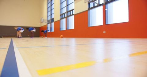 Diverse Girls Practicing Basketball in School Gymnasium