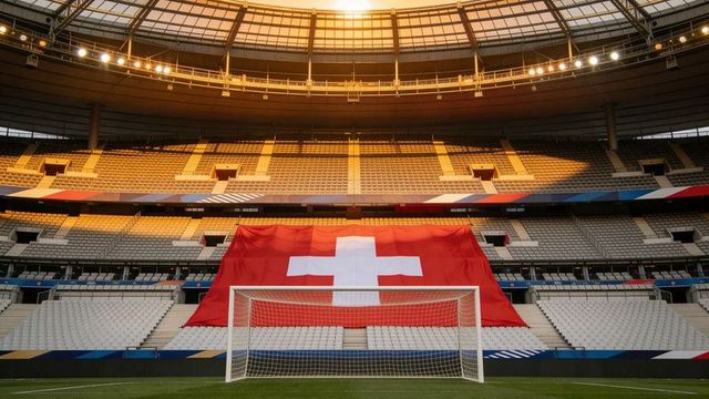 Swiss flag draping stadium seats behind goal at golden hour, symmetrical soccer arena