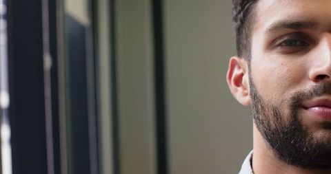 Confident Bearded Man Indoors with Contemplative Expression