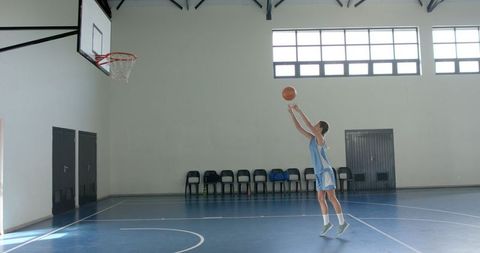 Female Basketball Player Practicing Shot in Empty Gym