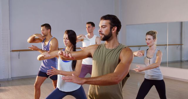 Group of adults practicing Tai Chi in fitness studio, highlighting relaxation and concentration. Image can be used for promoting wellness programs, fitness classes, meditation practices, or health and wellness blogs.