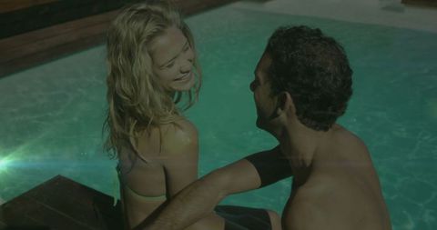 Smiling Couple Relaxing on Poolside Deck