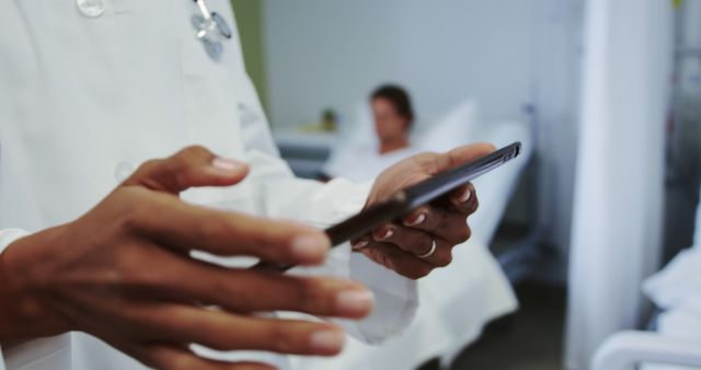 Doctor reviewing medical data on a smartphone in a hospital. The focus on digital tools highlights modern healthcare practices.