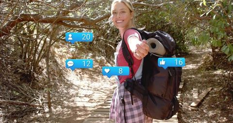 Smiling hiker extending hand on sunlit forest trail with social media notification icons