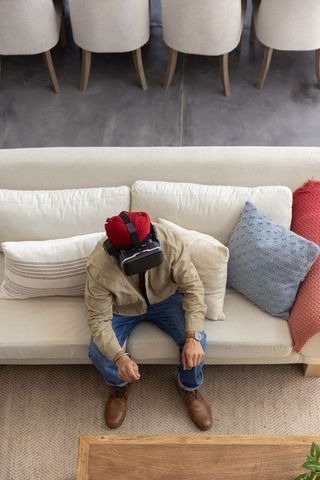 Man Experiencing Virtual Reality at Home on Sofa