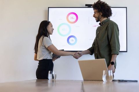Diverse Coworkers Shaking Hands at Modern Business Meeting