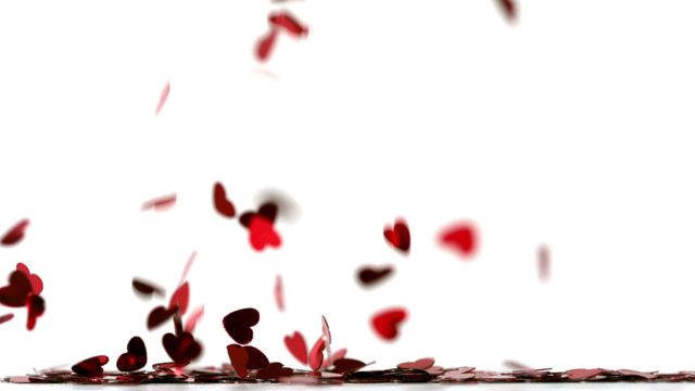 Heart-shaped red confetti pieces gently descending against a clean white backdrop. Ideal for themes of romance, celebration, Valentine's Day, anniversaries, or parties. Useful in advertising, social media posts, and event invitations for a joyful and festive atmosphere.