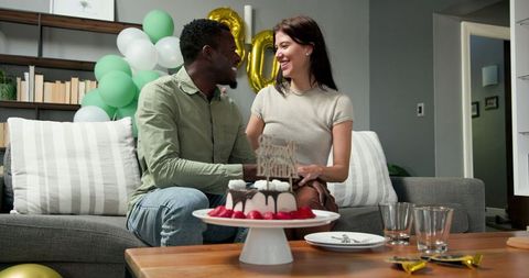 Happy Couple Celebrating Birthday with Cake and Festive Decorations