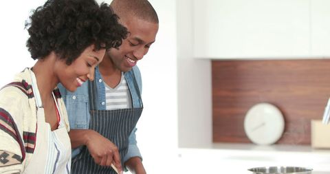 Young Couple Smiling While Cooking Together in Modern Kitchen - Download Free Stock Images Pikwizard.com