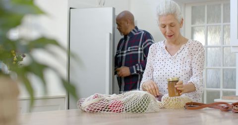 Senior Couple Unpacking Groceries in Cozy Home Kitchen