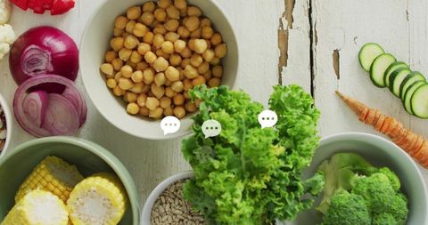 Curly kale and chickpeas flatlay displaying vibrant rustic vegetables on white wood table
