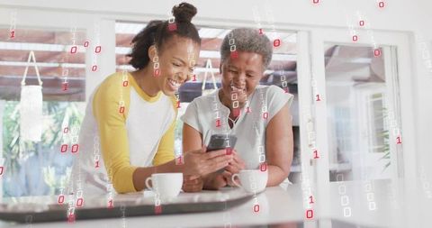 Intergenerational women sharing smartphone joy in bright kitchen with binary data overlay