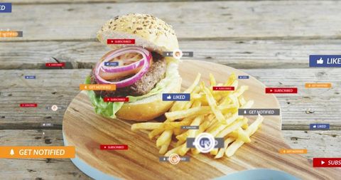 Sesame seed burger and fries on wooden board with social media notification overlays ui
