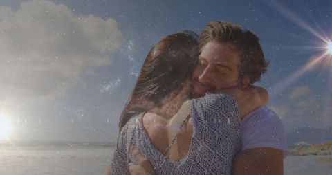 Romantic couple hugging on beach at sunset