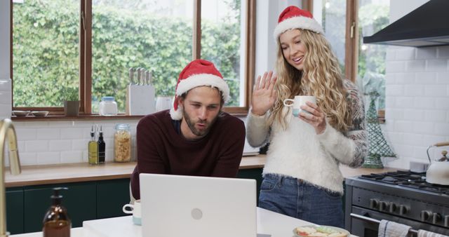 Happy couple in Santa hats making video call in kitchen during Christmas season - Download Free Stock Images Pikwizard.com