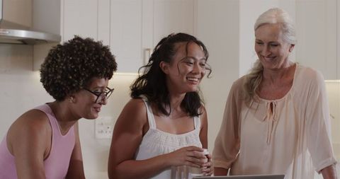 Smiling Women Collaborating on Wedding Plans in Kitchen Setting