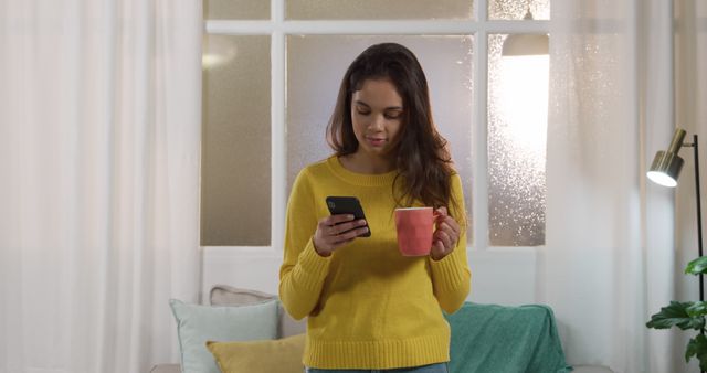 Woman enjoying morning coffee while using smartphone indoors - Download Free Stock Images Pikwizard.com