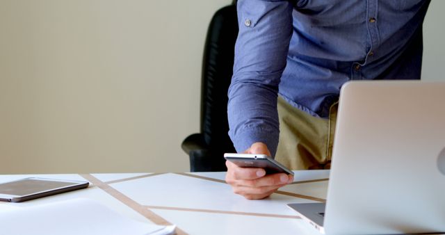 Young Professional Checking Smartphone in Office Setup - Download Free Stock Images Pikwizard.com