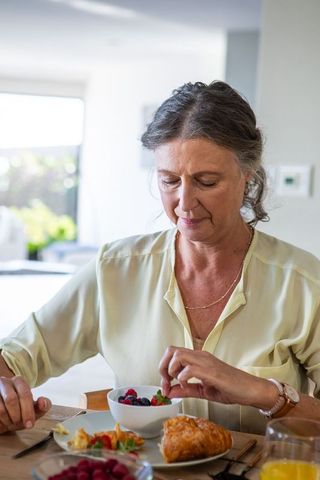 Elegant senior woman enjoying healthy breakfast at home
