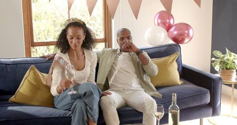Couple relaxing with wine during home celebration