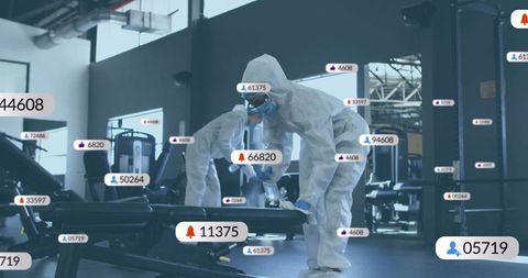 Technicians Disinfecting Gym Equipment with Data Interface