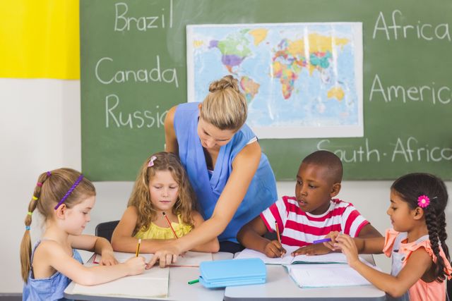 Teacher helping kids with their homework in classroom - Download Free Stock Photos Pikwizard.com