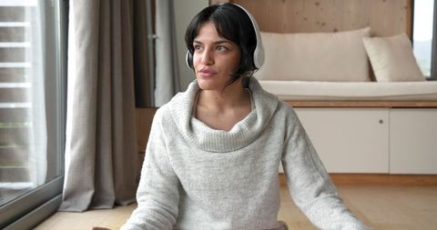 Woman Practicing Mindfulness with Headphones in Cozy Scandinavian Home