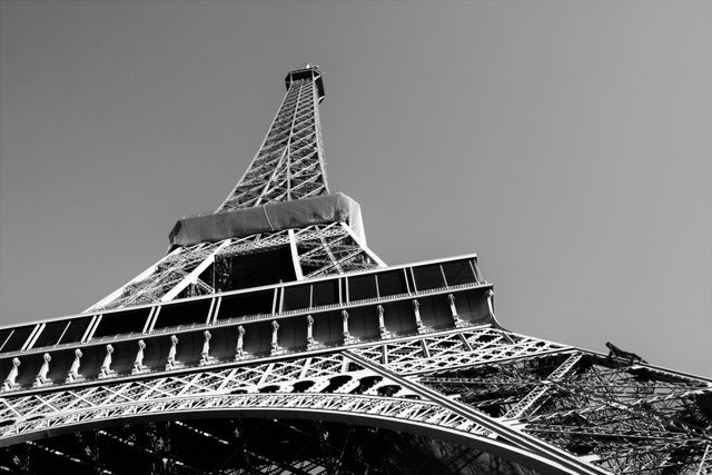 Captivating upward perspective of the Eiffel Tower in monochrome offers a classic view of this iconic Parisian landmark. Ideal for travel blogs, architecture studies, tourism promotions, and posters celebrating European culture and historic structures.