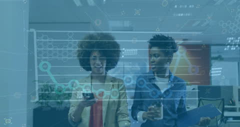 Two Businesswomen Analyzing Digital Data Holograms in Office Environment