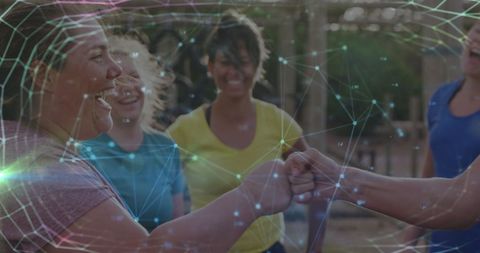 Diverse women fist bumping at fitness obstacle course