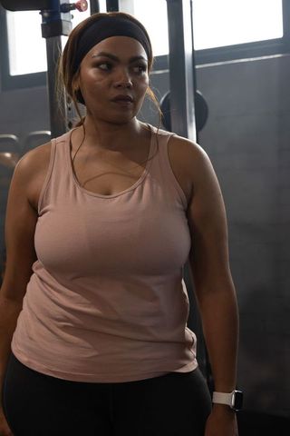 African american woman working out in gym, determined expression, strength training