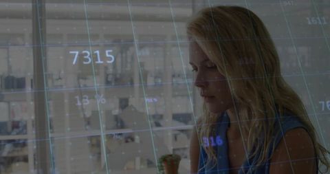 Businesswoman Analyzing Data Grid Overlay in Modern Office Environment