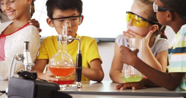 Diverse group of children wearing safety glasses and conducting science experiments with lab equipment in classroom. Great for educational websites, school brochures, and learning materials on STEM activities and classroom environment.