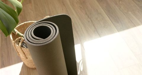 Rolled Yoga Mat on Sunlit Wooden Floor with Basket and Plant - Download Free Stock Images Pikwizard.com