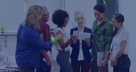 Mature female leader guiding multiracial team with tablet and smartphone in modern office