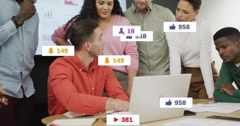 Diverse team reviewing analytics dashboard around laptop during office meeting