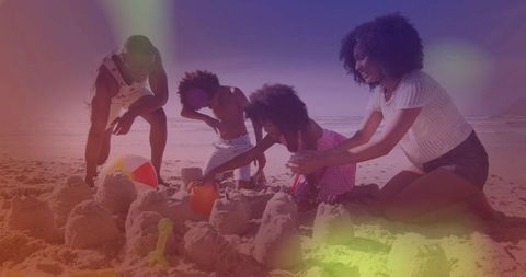 Family Building Sandcastles Together on Sunny Beach