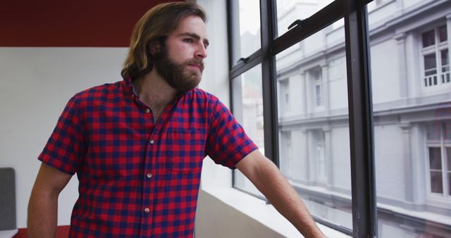 Pensive Man in Checkered Shirt Looking Out Window - Download Free Stock Images Pikwizard.com