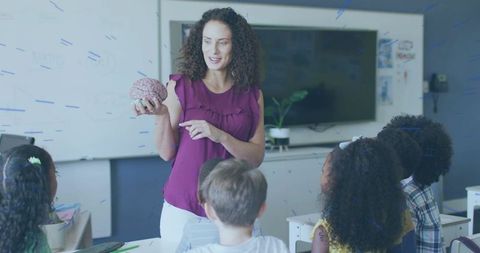 Teacher Holding Brain Model Teaching Neuroscience to Elementary Students in Classroom