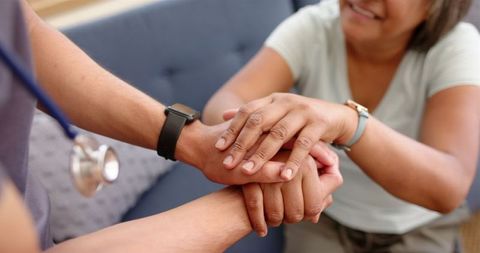 Caregiver offering support to elderly woman with compassion