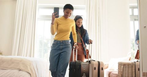 Diverse Female Friends Arriving at Hotel Room with Luggage